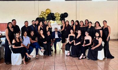 Grupo grande de personas elegantemente vestidas para un evento formal.