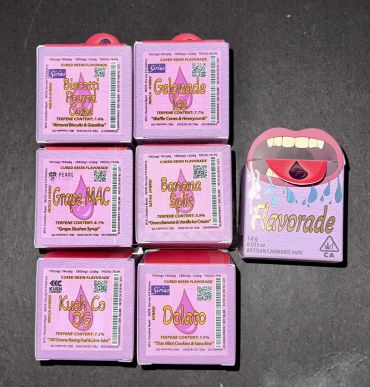 Six colorful cannabis product boxes with unique flavor names on display.