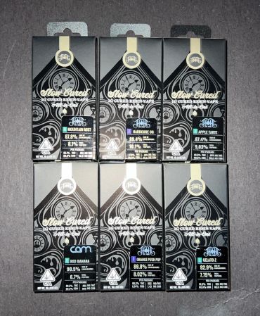 Seven black cannabis product boxes with distinct strain labels arranged in two rows.