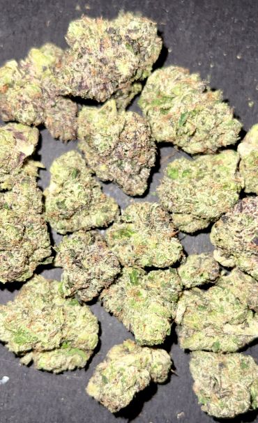 Close-up of cannabis buds on a dark surface.