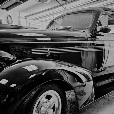 Close-up of a shiny vintage black car in a garage.