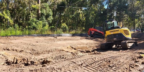 Construction site with two excavators and dirt ground.