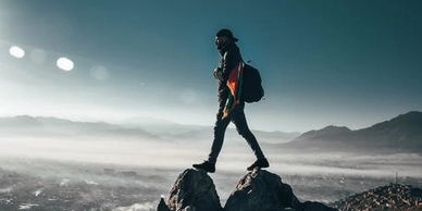 A man walking on two rocks in the mountains