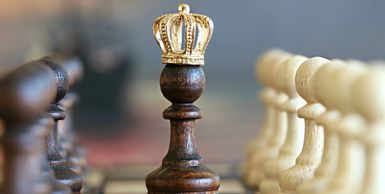 A chess pawn with a gold crown