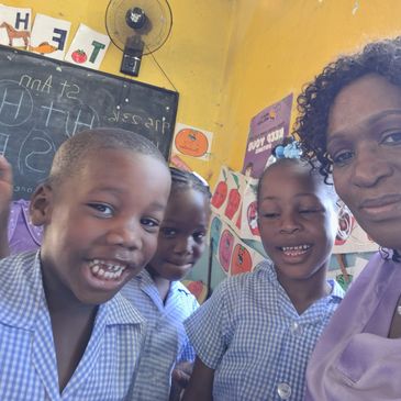Smiling children and teacher in a colorful classroom.