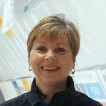 Smiling middle-aged woman with short hair indoors.