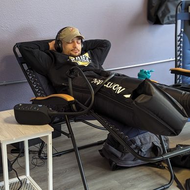 Client enjoying compression therapy with normatec 3 compression boots.