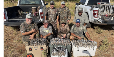 A soldier sit down with dove hunts and looking on the camera