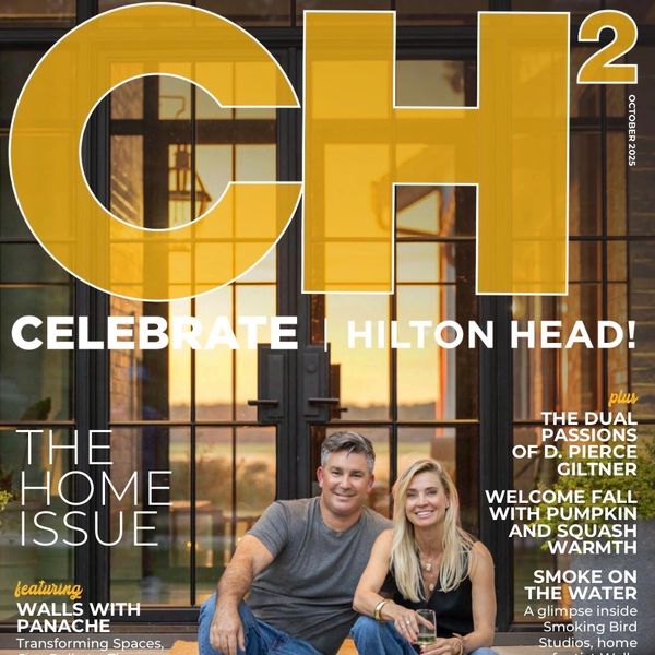 Couple smiling in front of large glass doors on magazine cover.