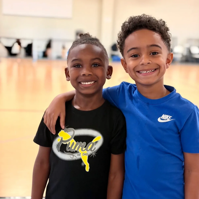 Two smiling boys posing with their arms around each other.