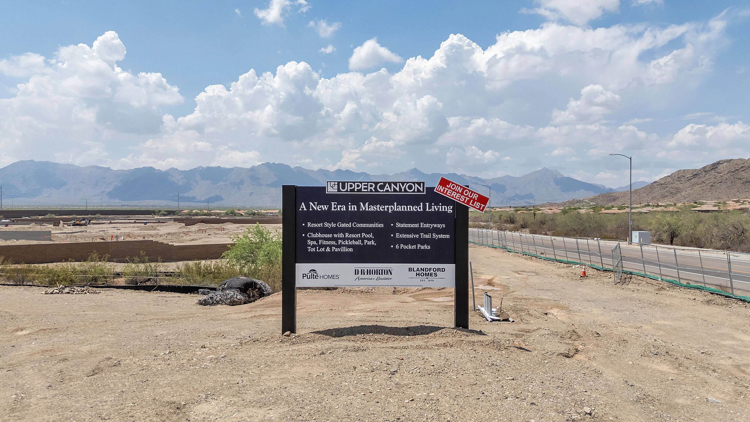 Sign for Upper Canyon masterplanned living community in a desert area with mountains.