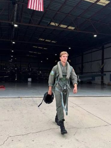 Pilot walking out of a hangar with helmet.