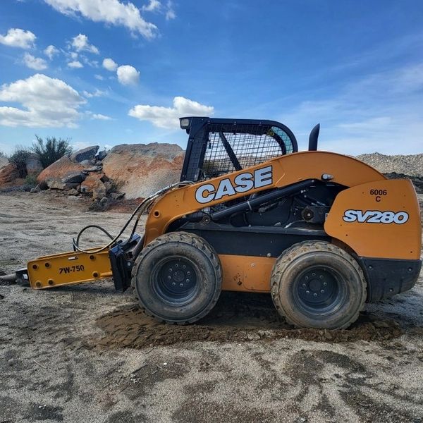CASE SV280 skid steer loader on a construction site under a clear sky.