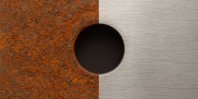 Rusty metal on one side, polished metal on the other, divided by a circular hole.