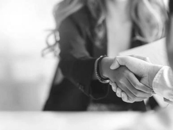 Two people shaking hands in a professional setting.