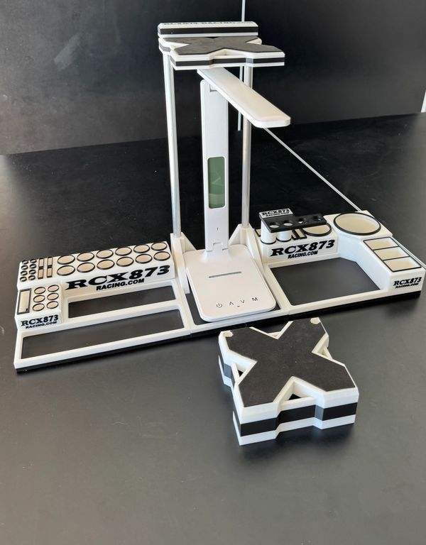 White and black RCX 873 racing tool with various slots and a detachable cross-shaped part.