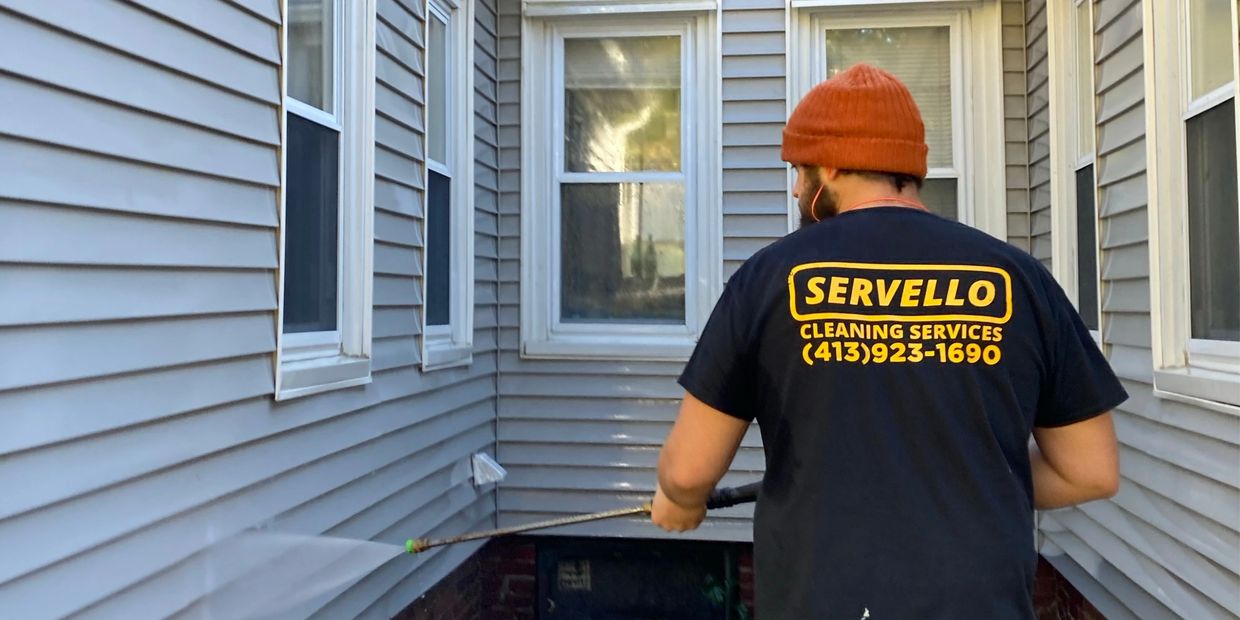 A large, beautiful home professionally cleaned by a uniformed pressure washer 