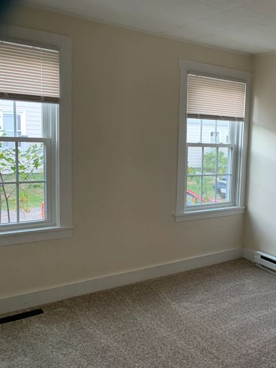 Vacant living room with clean floors and window light ready for move-in