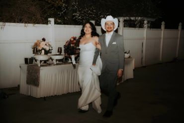 Newlywed couple walking arm in arm, radiating happiness after their wedding ceremony.