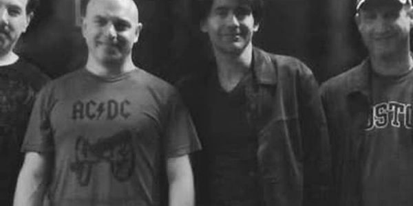 Group of men posing for a photo in black and white.