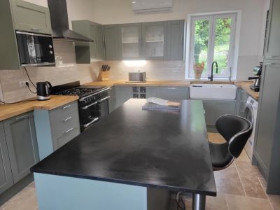 Modern kitchen with a central island and wooden countertops.