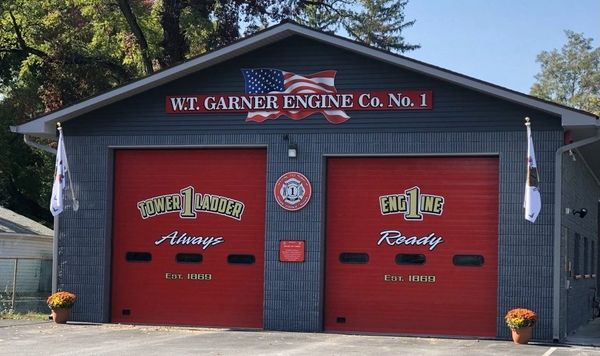 Fire station with red garage doors and American flag.