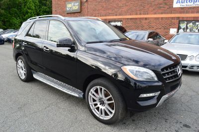 Black Mercedes-Benz SUV parked outside a brick building.