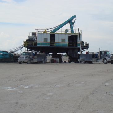Large industrial crane setup on a construction site with trucks nearby.