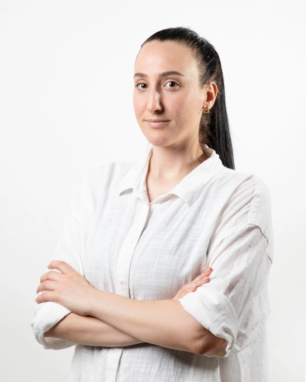 Confident woman with arms crossed wearing a white shirt.