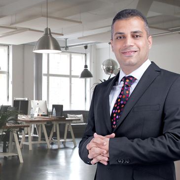 Confident businessman posing in a modern office space.