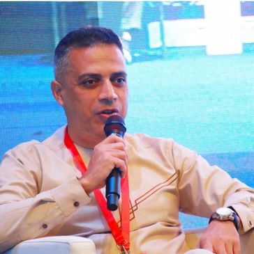 Man speaking into a microphone at an event.