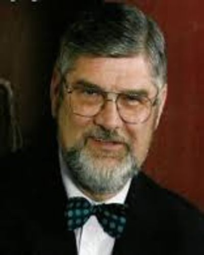 Portrait of an older man with glasses and a bow tie.