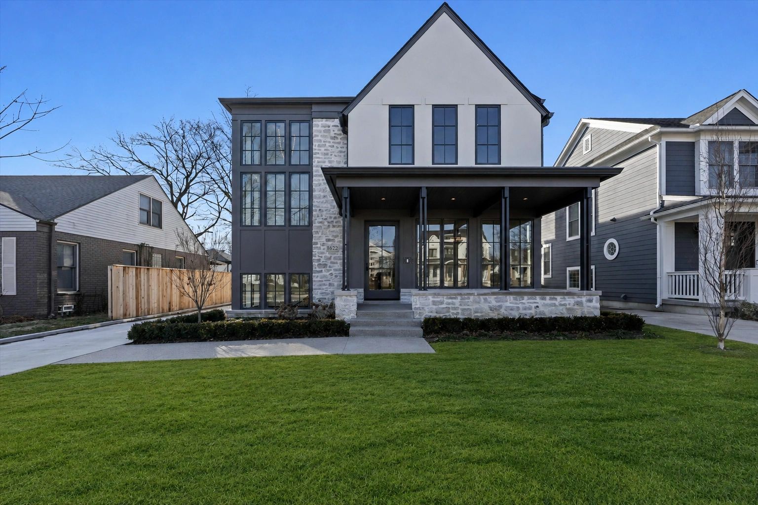 Modern two-story house with stone and dark trim exterior.