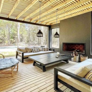 Cozy outdoor seating area with wooden deck and modern fireplace.