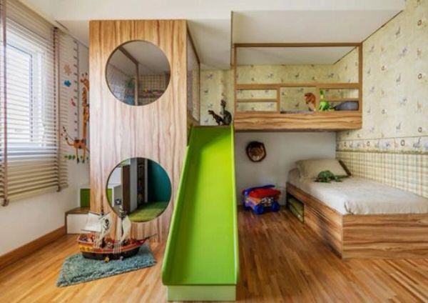 Habitación infantil con tobogán verde y cama.