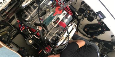 Person working on a complex engine inside a compact engine room.