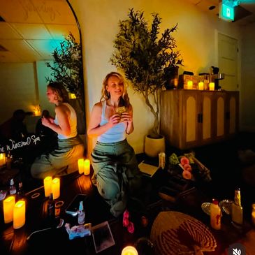 Woman enjoying a cozy candle-lit room.