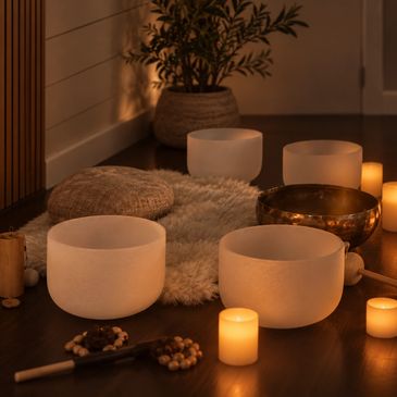 Cozy meditation space with candles and singing bowls.