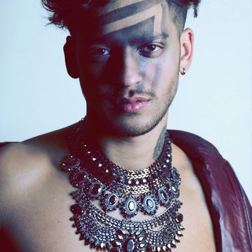 Homme portant plusieurs colliers ornés.