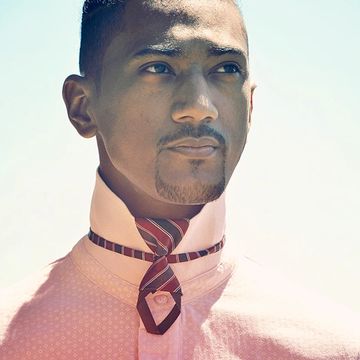 Homme portant une chemise rose avec cravate non nouée.