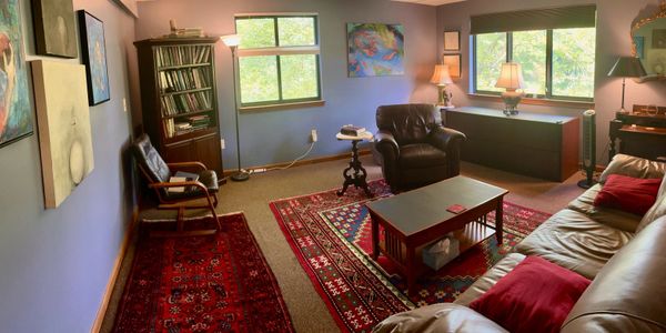 Cozy living room with leather seating and vibrant rugs under soft lighting.
