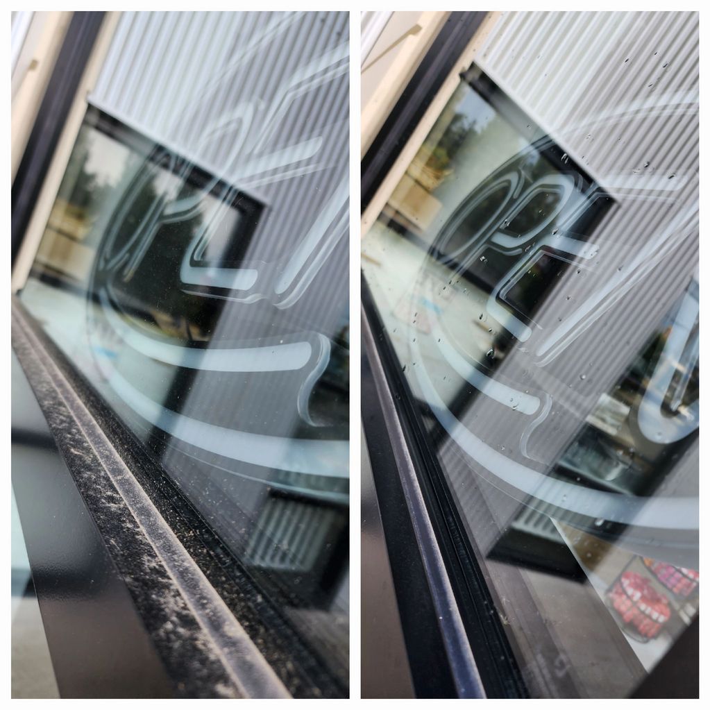 Clean storefront window with 'open' sign, reflecting surroundings after exterior cleaning.
