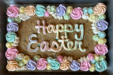 Easter cookie cake with pastel frosting and the words 'Happy Easter'.