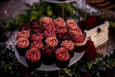 Plate of cupcakes with pink and red frosting.