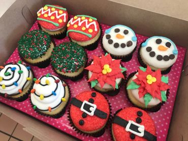 Box of Christmas-themed decorated cupcakes.
