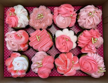 Box of decorated pink and white cupcakes.