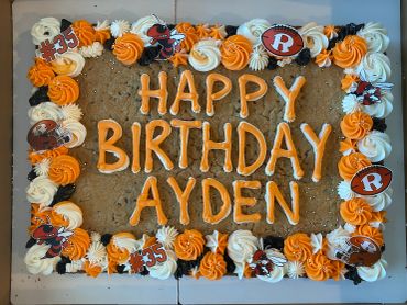 Birthday cookie cake decorated with orange and white frosting.