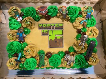 Minecraft-themed birthday cake decorated with characters and green and yellow frosting.