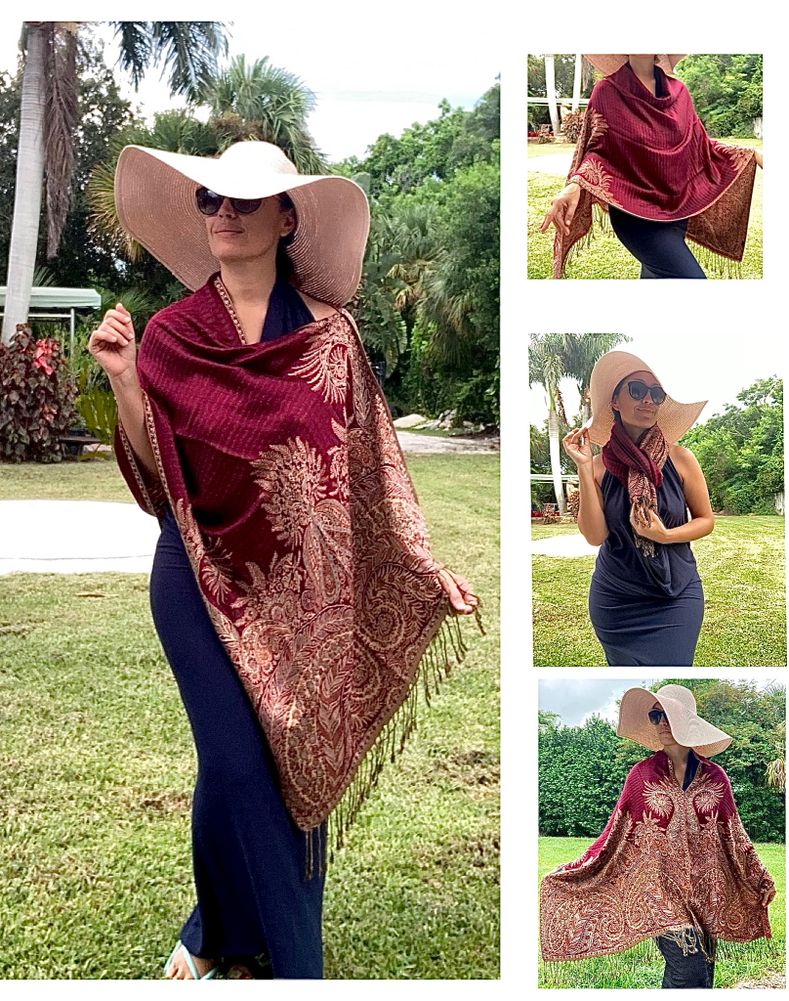 Woman wearing a one size shawl poncho over dress outside in a park while on vacation over a dress. 