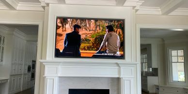 A modern living room with a TV mounted above a white fireplace.